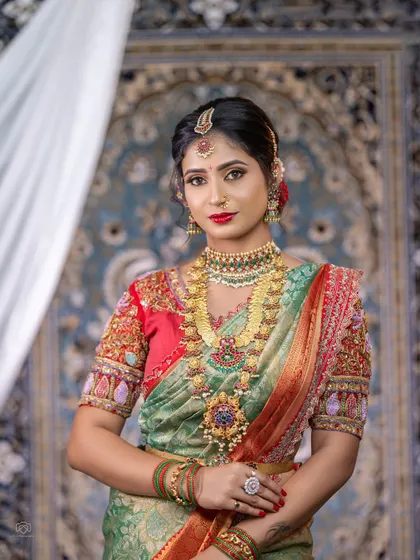 This bride chose a beautiful kemp jewellery set with a unique Kasu Mala design. The mix of red, green, and gold is a classic combination for South Indian weddings.