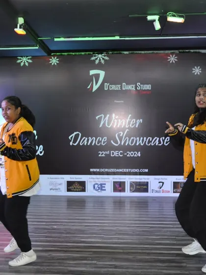 The duet continues their energetic routine in front of the Winter Showcase backdrop.