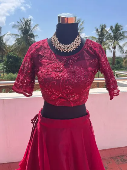 The delicate net and embroidery detail on the blouse of the wine-red lehenga.