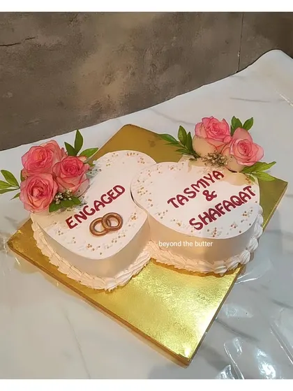 A double heart cake is a perfect way to celebrate an engagement. This one is decorated with delicate pink roses and inscribed with the names of the happy couple.