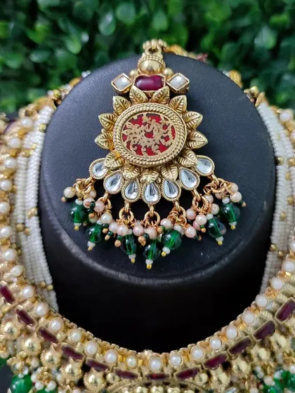 The beautiful maang tikka from this set, featuring the same red engraved pendant design to create a perfectly coordinated bridal look.