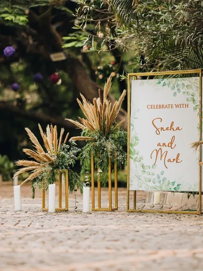 A rustic and elegant welcome sign, accented with pampas grass and candles, setting a warm and natural tone for the celebration.