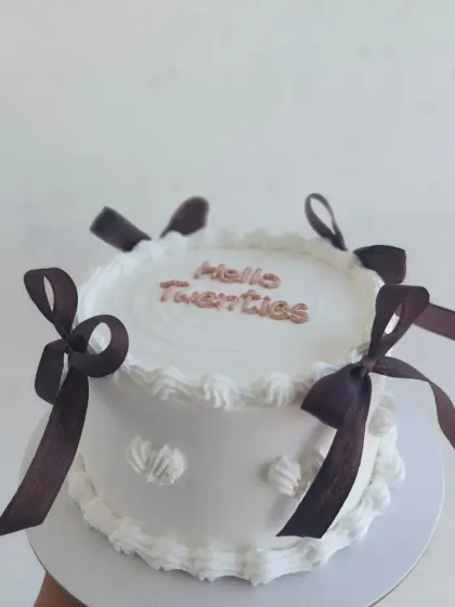 A "Hello Twenties" vintage cake with brown ribbons, a perfect way to celebrate a milestone birthday in style.
