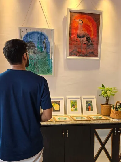 A visitor at the "Vibing with Nature" exhibition by artist Puja Kumari. We invite you to come and explore her unique and meaningful collection.