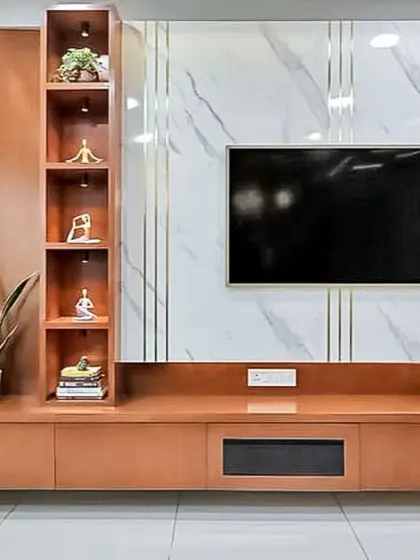 This TV entertainment unit features a striking marble-finish back panel with brass inlays. The wooden console provides ample storage and a display niche, combining luxury with practicality.