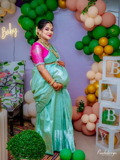 A slightly different angle of the mother-to-be at her party, capturing her elegance and the festive atmosphere.