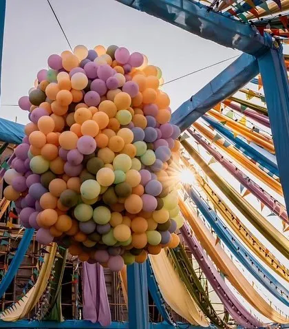 A stunning balloon drop installation hanging from a colorful tented ceiling, ready to shower the party in fun.