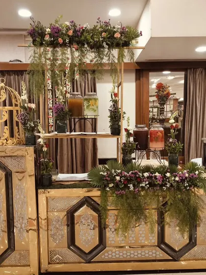 Another view of the rustic-chic beverage station, showing the arrangement of dispensers and floral decor.