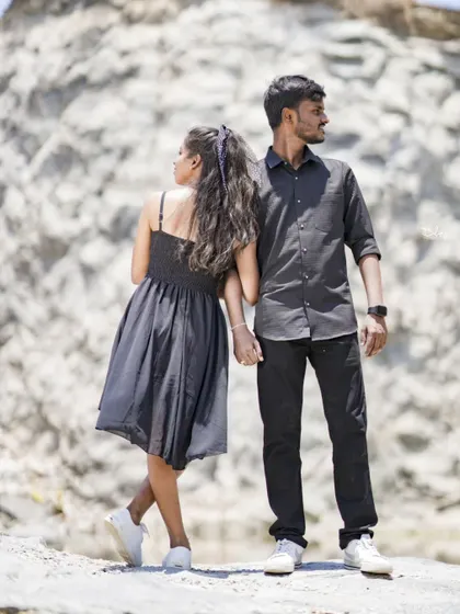 A simple but beautiful pre-wedding photo against a natural rock formation. The focus is entirely on the couple's connection.