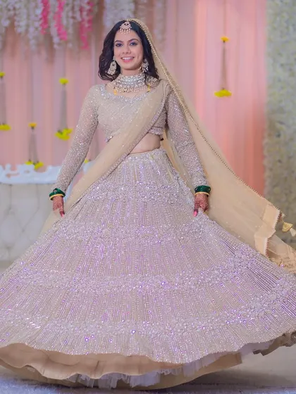 A twirl-worthy reception lehenga. The makeup is designed to complement the grandeur of the outfit, creating a show-stopping look.
