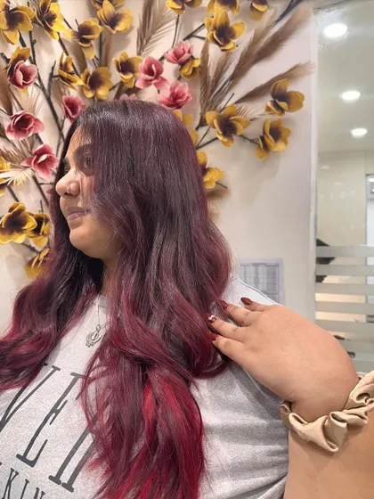 A final look at the client enjoying her new red ombre hair. The style is both edgy and glamorous.