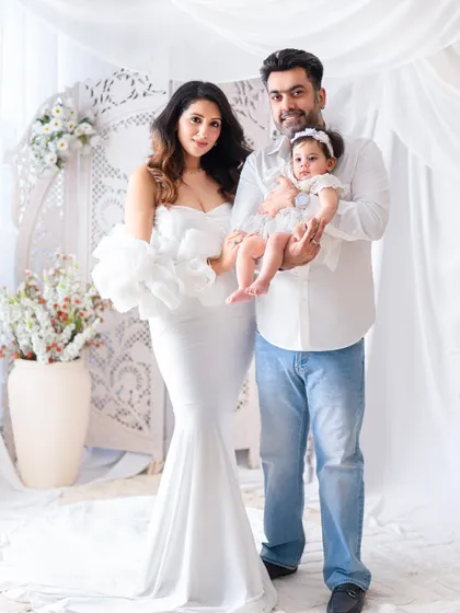 A classic family pose against a beautiful white backdrop. This elegant portrait showcases the family's style and connection.