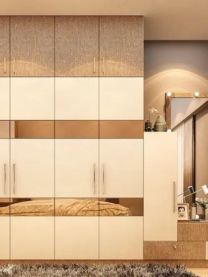 This wardrobe combines textured laminate on the upper cabinets with high-gloss white doors below. A band of reflective bronze mirror runs through the center, adding a sleek, modern touch to the design.