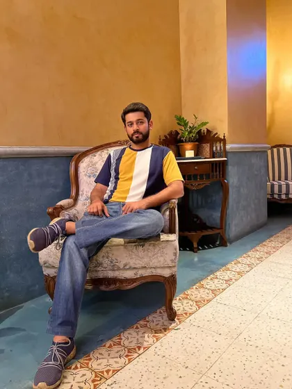 A full-body shot, seated in a stylish armchair. This demonstrates a relaxed yet composed posture, ideal for interior decor, cafe, or fashion lookbook shoots.