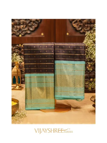 A stunning black Kanjivaram with a striking blue border and luxurious gold zari weaving.