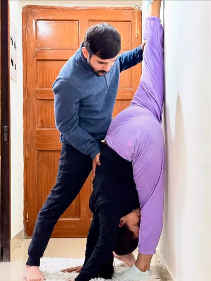 A closer look at assisting a client in a standing split. My hands-on approach ensures they don't overstretch and maintain proper hip alignment.