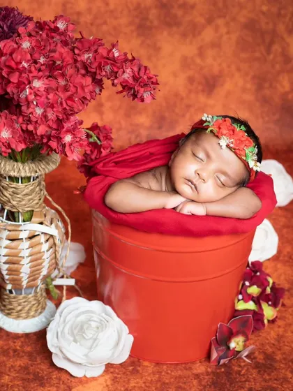 A close-up of the newborn in the red bucket, looking peaceful and content.
