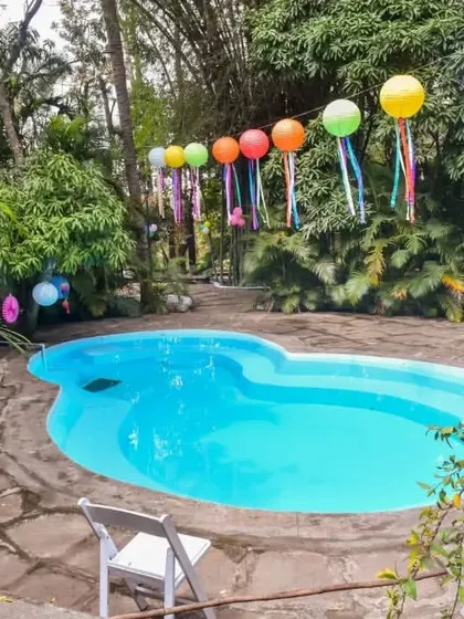 The pool area at this outdoor kids' party was decorated with colorful balloons with ribbon tails, adding a festive and playful touch to the space.