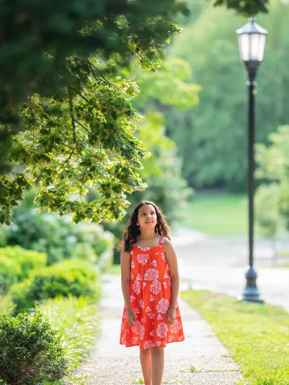 A thoughtful portrait of my daughter walking down a path, framed by lush greenery. These are the memories I know I'll cherish forever.