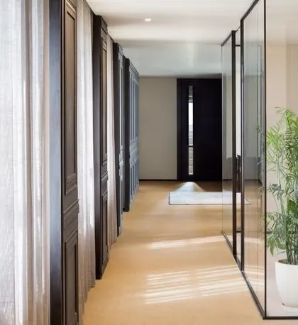 A hallway with glass partitions and natural light, demonstrating our approach to creating bright and airy transitional spaces.