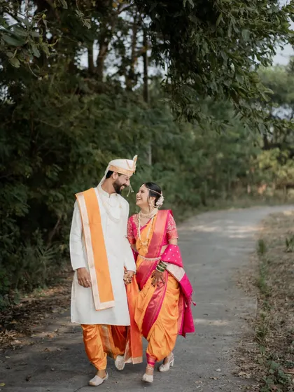 The couple shares a happy moment walking hand-in-hand down a country path after their wedding.