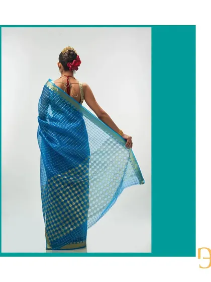 A final look at the back of the Persian blue saree, capturing the elegance of its drape and the detailed zari work.