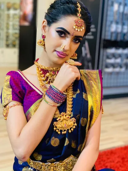 A striking pose from a South Indian bridal photoshoot. The focus is on the bold eye makeup and the intricate details of the traditional jewelry.