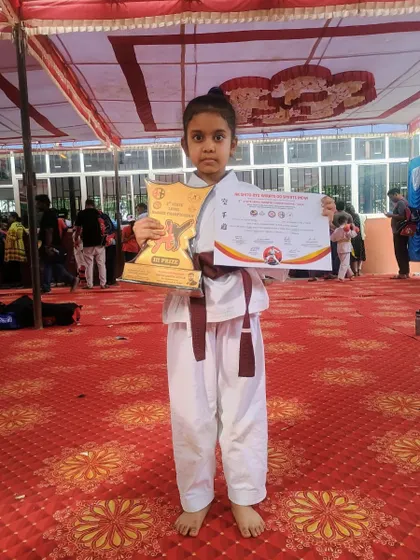 Standing tall with her trophy and certificate. Each tournament is a valuable learning experience, building character both on and off the mat.
