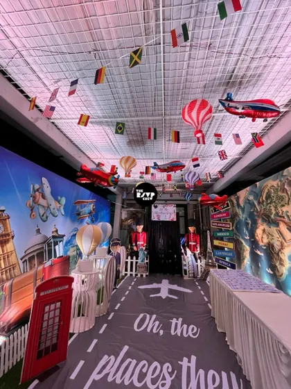 Oh, the places they'll go! This travel-themed party entrance features an airplane runway floor, world map walls, and flags from different countries hanging from the ceiling.