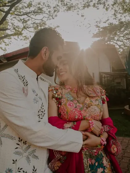 A sun-flared shot of the couple embracing, creating a dreamy and romantic atmosphere.