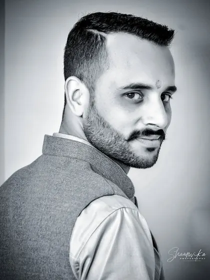A sharp black and white headshot of a groom. This intimate portrait captures a confident and direct gaze, making for a powerful image.