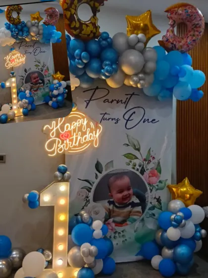 A sweet donut-themed first birthday setup. This decoration includes a custom backdrop with the baby's photo, a light-up number '1', and fun donut-shaped foil balloons.