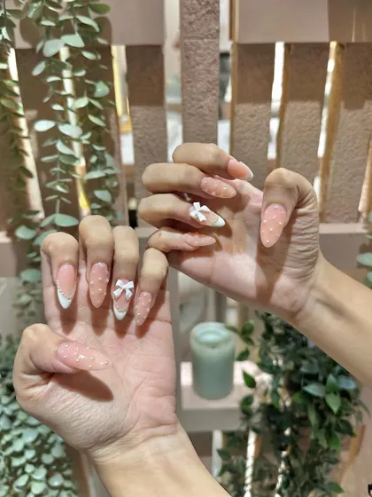 A still shot capturing the sparkle and detail of these bow and polka dot nails. We love creating designs that are packed with cute details.