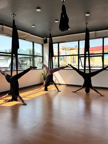 Students open up into a star-like shape, demonstrating flexibility and control while inverted.