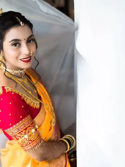 A creative bridal portrait taken during the getting-ready process. The flowing white fabric adds a sense of movement and drama to the shot.