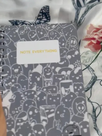 A close-up of the grey A5 notebook, also featuring the all-over doodle pattern.