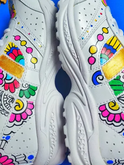 A pair of plain white sneakers transformed with vibrant, hand-painted floral and mandala-inspired patterns, showcasing my custom wearable art service.