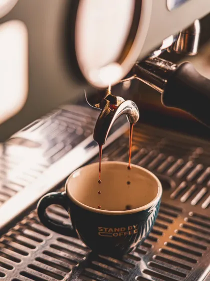 A close-up macro shot of espresso being extracted. Capturing the process of coffee making is just as important as the final cup.