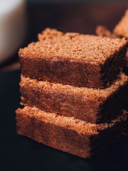 A stack of rich, dark brownies, shot in a moody, warm light. This style creates a cozy, indulgent feeling that is perfect for dessert photography.