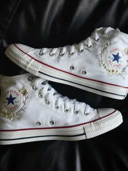 A pair shot showing the embroidery on both sides of the Converse.