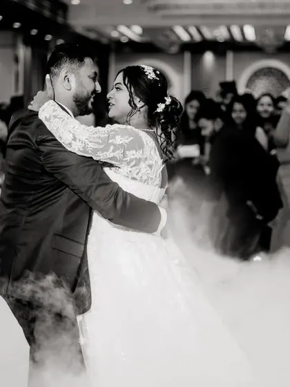 The first dance, surrounded by the soft glow of dry ice. This black and white photo captures the intimacy and romance of the moment.