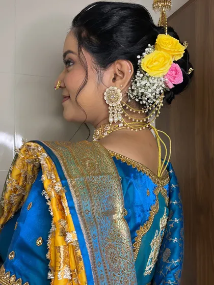 A view of the bride's beautiful hairstyle, a modern take on a traditional bun, adorned with fresh flowers.