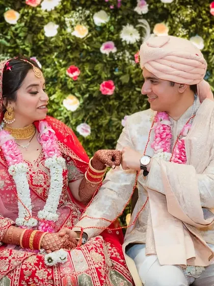 A fun, candid moment during the wedding ceremony. The couple engages in a playful ritual, their expressions full of mischief and love.