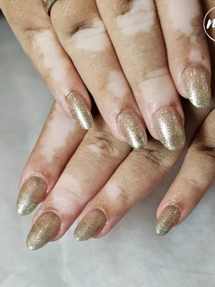 A full set of champagne gold glitter nails. This is a great choice for a celebratory event or for anyone who loves a bit of sparkle in their life.