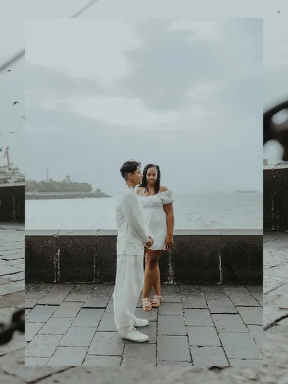 A beautifully framed portrait of the couple standing by the sea, creating a sense of intimacy and focus on their relationship.