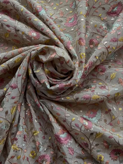 A close-up of our embroidered tissue fabric, showing the dense multi-color floral embroidery and sequin work that gives it a luxurious, festive feel.