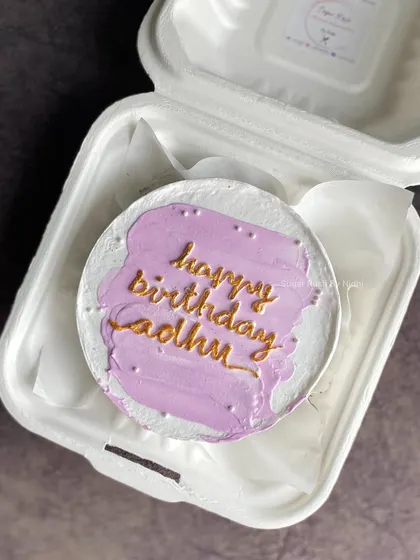 A simple and chic lavender bento cake with gold lettering. This minimalist design is perfect for a stylish birthday celebration.