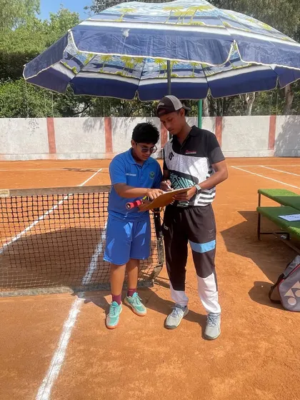 A coach reviewing the scoresheet with a player during our internal tournament. We use these events as valuable teaching opportunities.