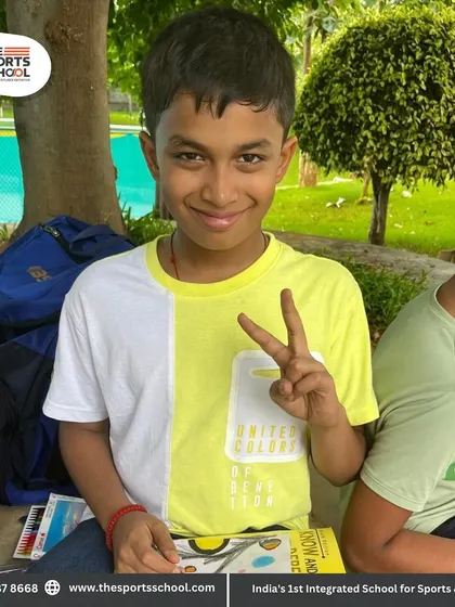 A student gives a peace sign, happy with his outdoor learning session.