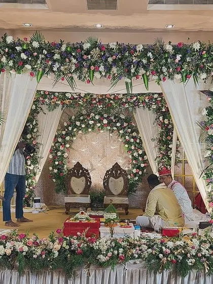 A beautiful floral mandap with traditional seating, ready for a Hindu wedding ceremony.